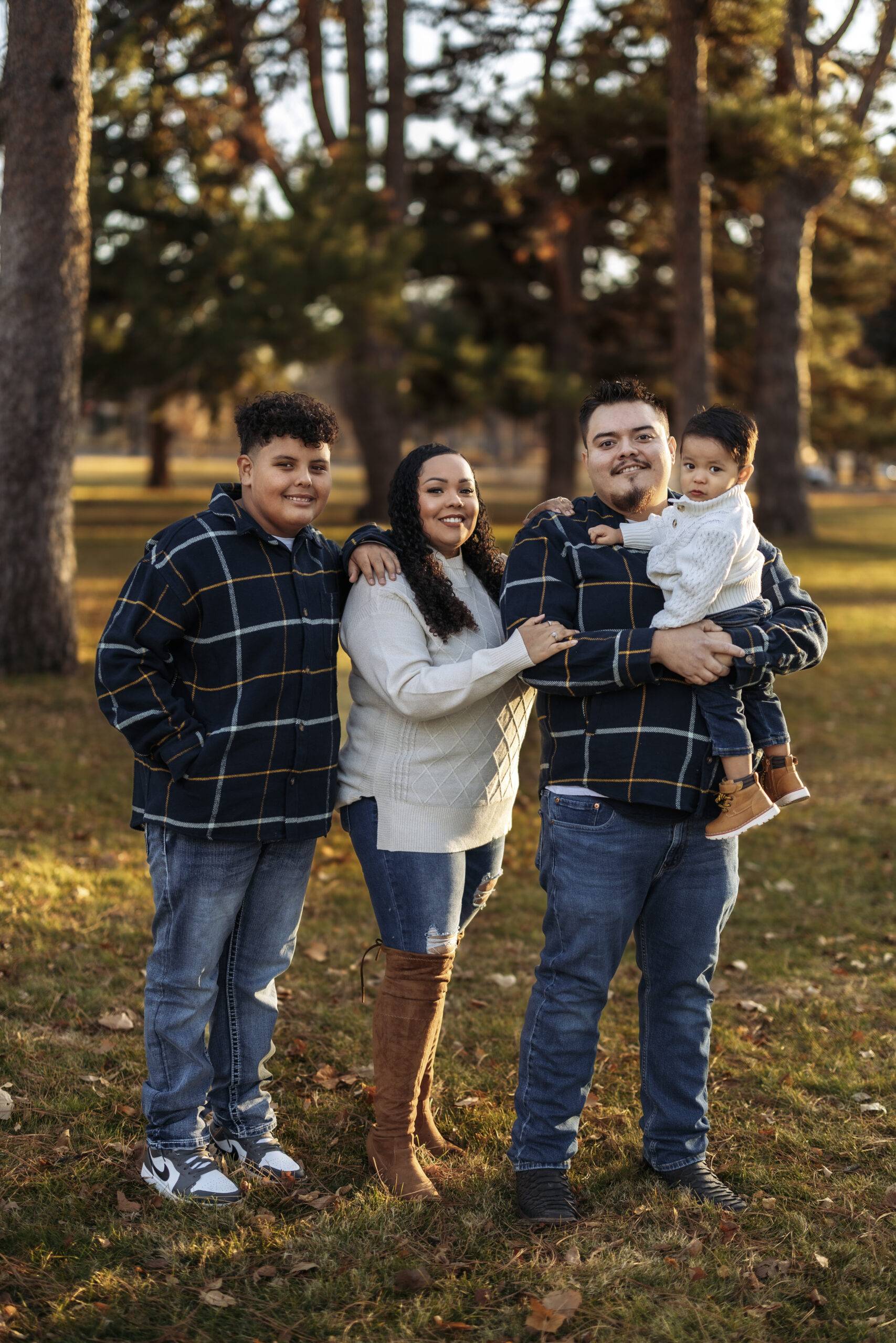 A family of four posed together at a park.